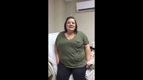 A woman in a green shirt shares her gastric sleeve success story in a hospital room.